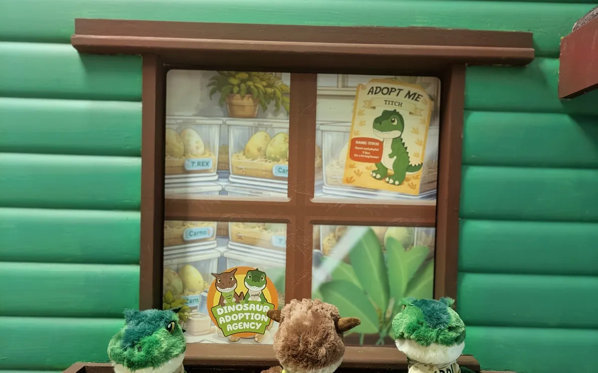 The Dinosaur Adoption Agency window display with mini plush dinosaurs and an Adopt Me card