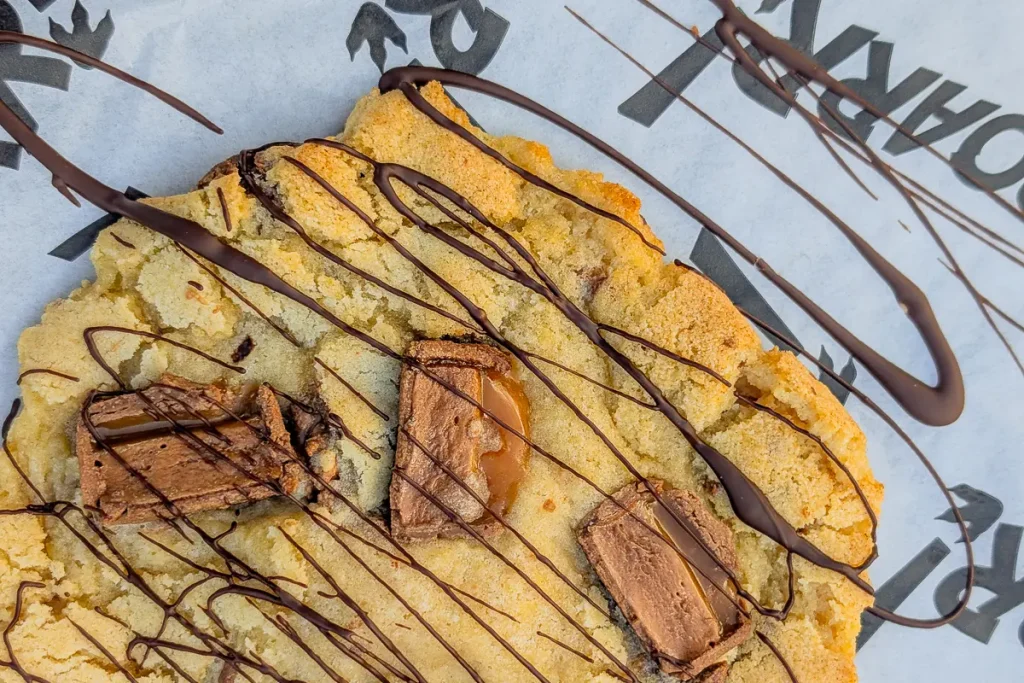 Giant chocolate-drizzled cookie on ROARR! branded paper at Dinomite Café