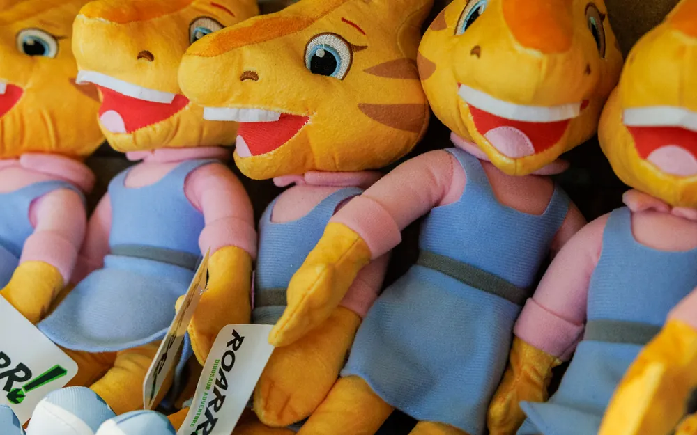 A shelf of plush ROARR! character soft toys in the ROARR! STORE