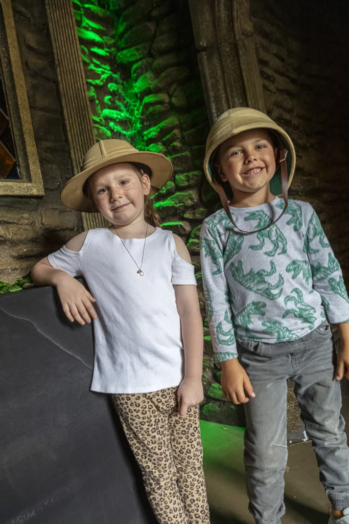 Two young explorers wearing safari hats inside Dino Hunter Exploration